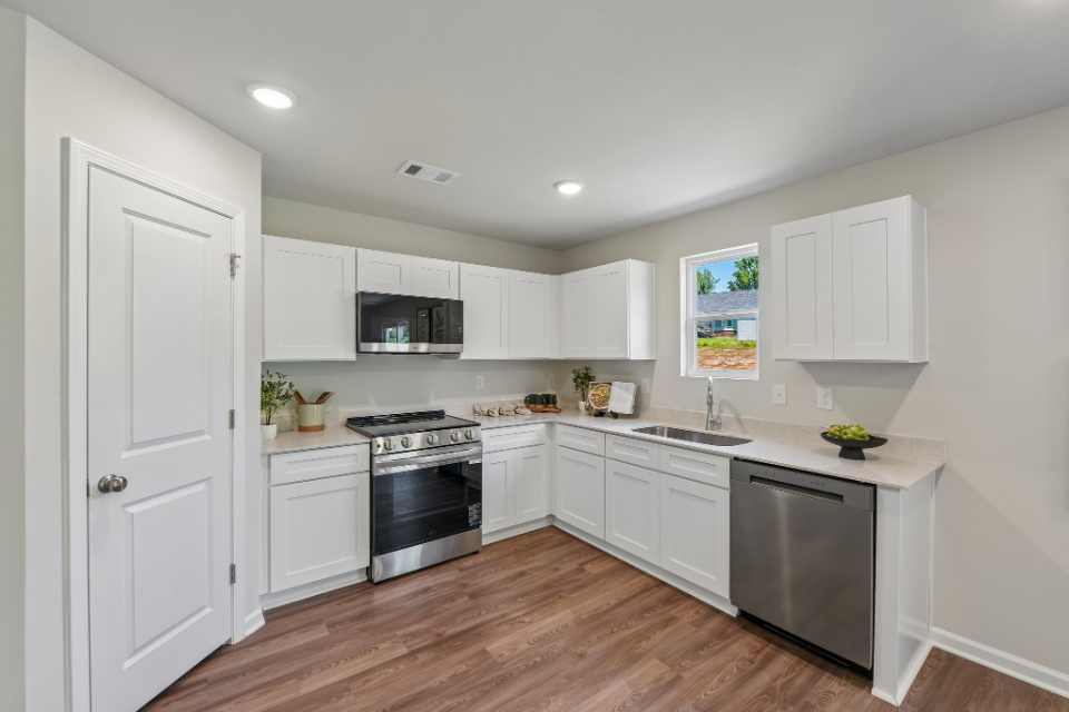 A kitchen with white cabinets.