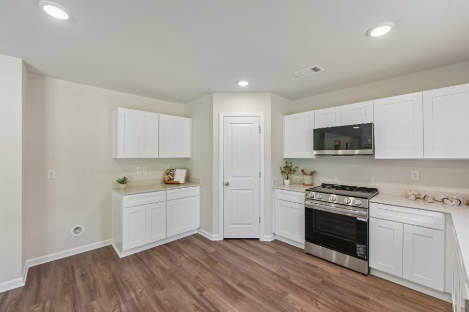 A kitchen with white cabinets.