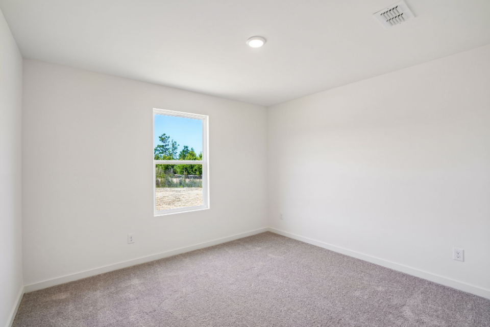 A room with a window and a carpet.