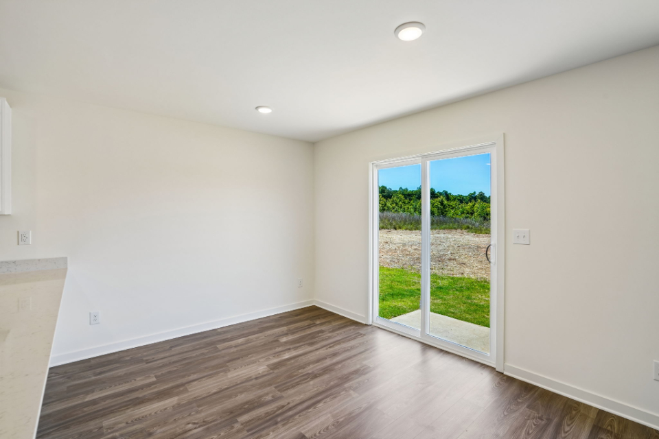 A room with a wood floor and a wood floor with a window.