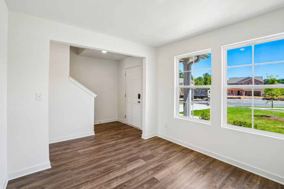 A room with a wood floor and windows.