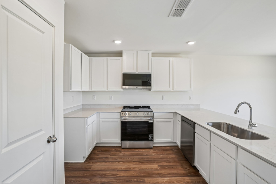 A kitchen with white cabinets.