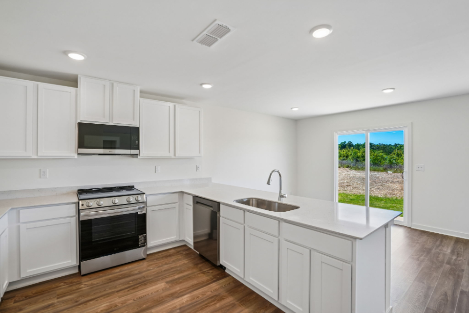 A kitchen with white cabinets.