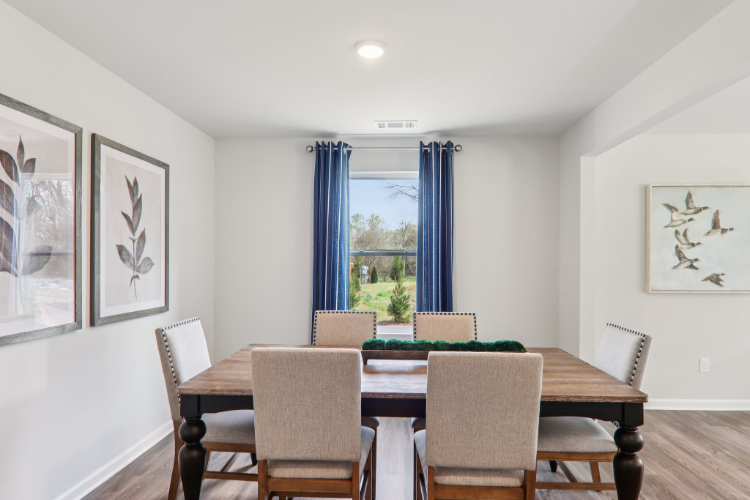 A dining room with a table and chairs.