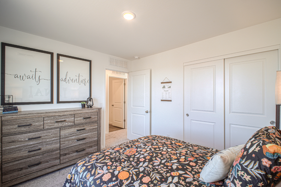 A bedroom with a bed and dresser.