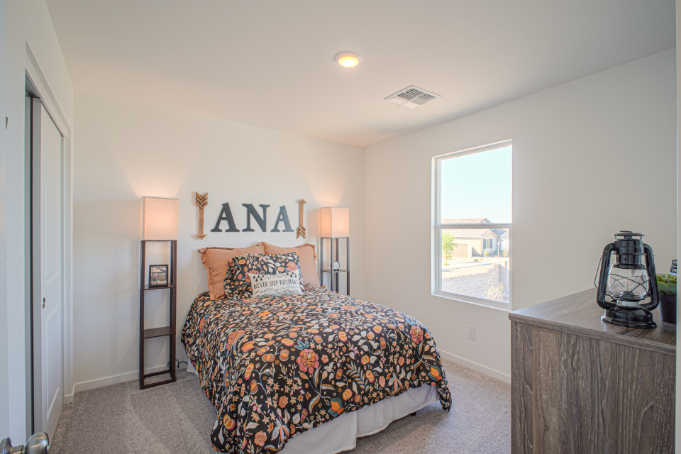 A bedroom with a bed and lamps.