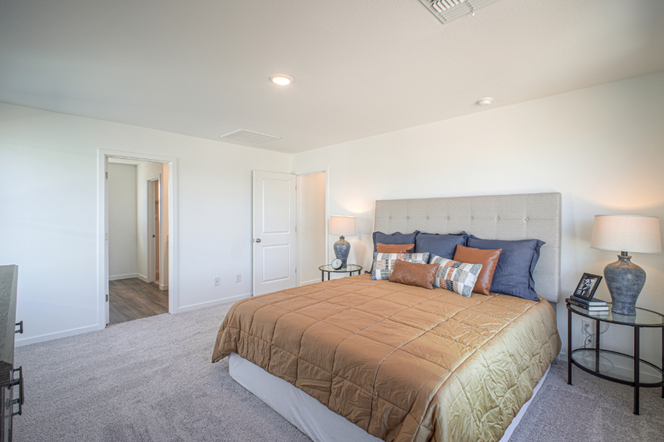 A bedroom with a bed and lamps.