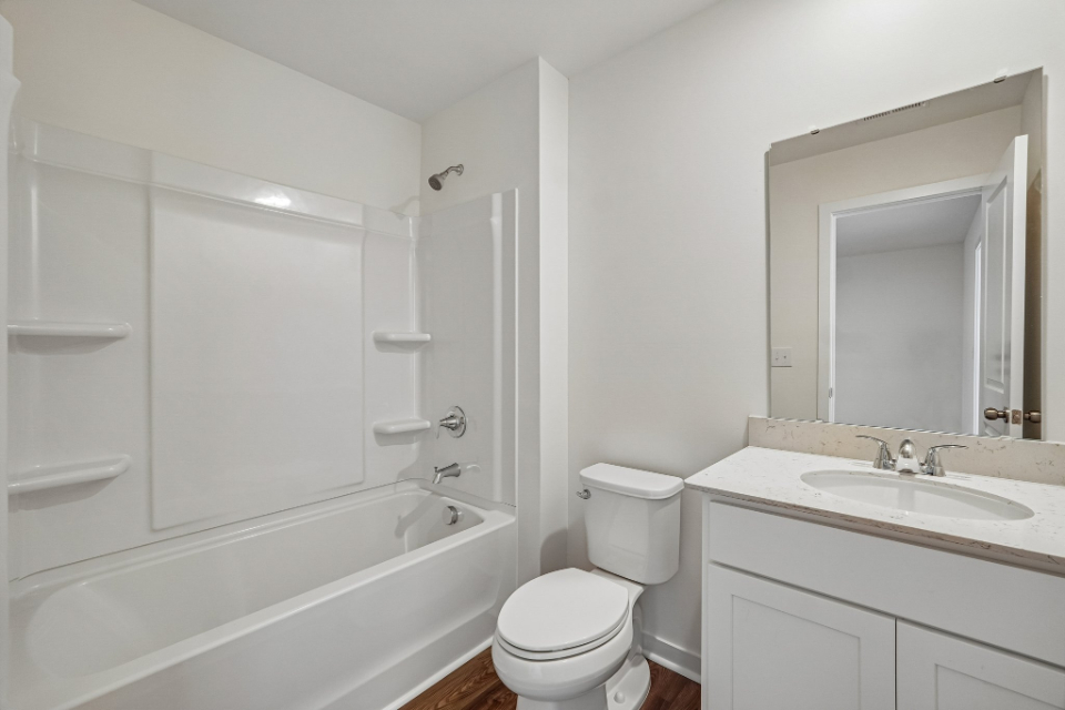A bathroom with a tub sink and toilet.