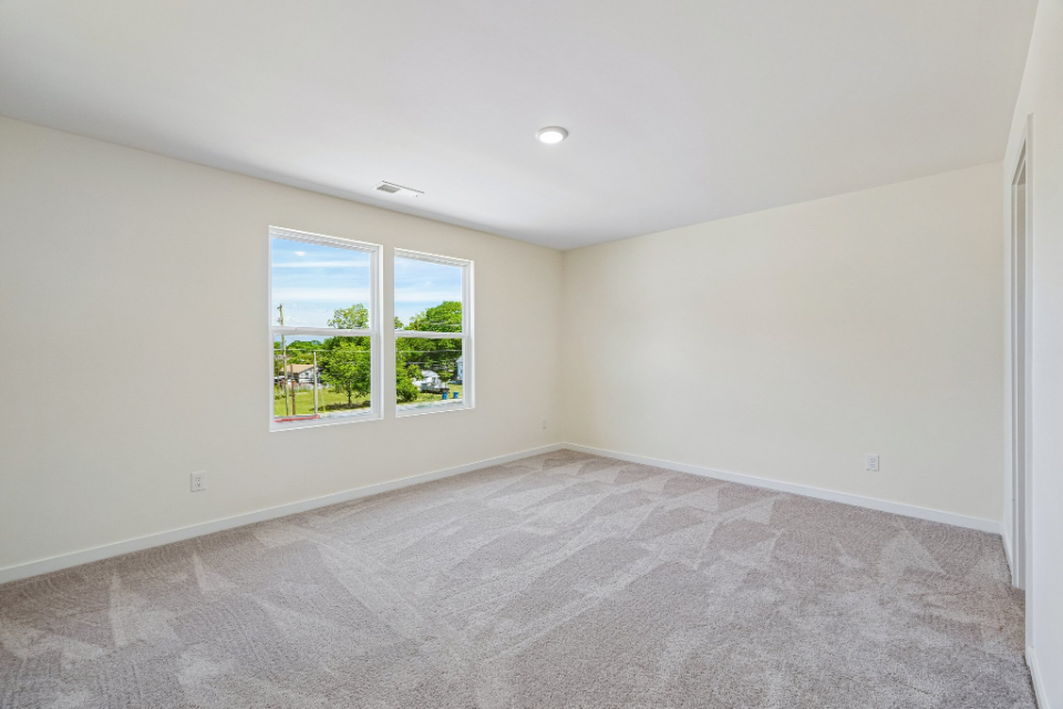A room with a carpet and windows.