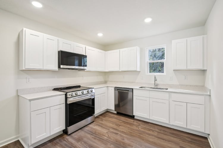 A kitchen with white cabinets.