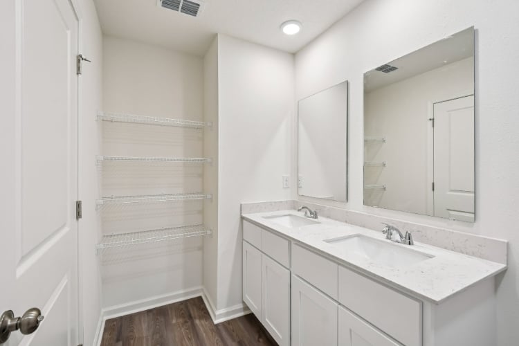 A bathroom with white cabinets.