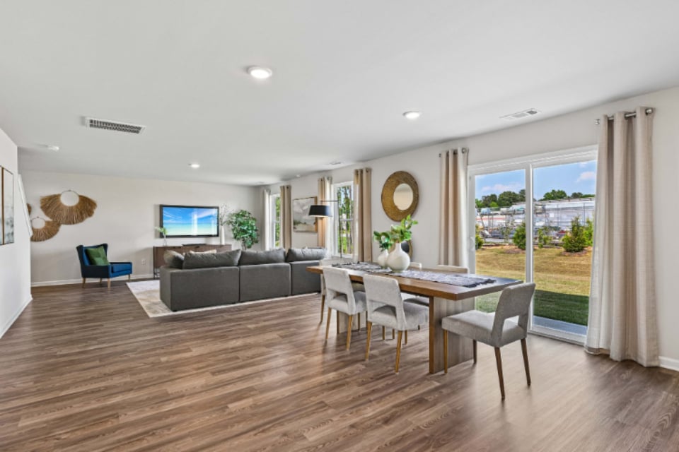 A living room with a large table and chairs.