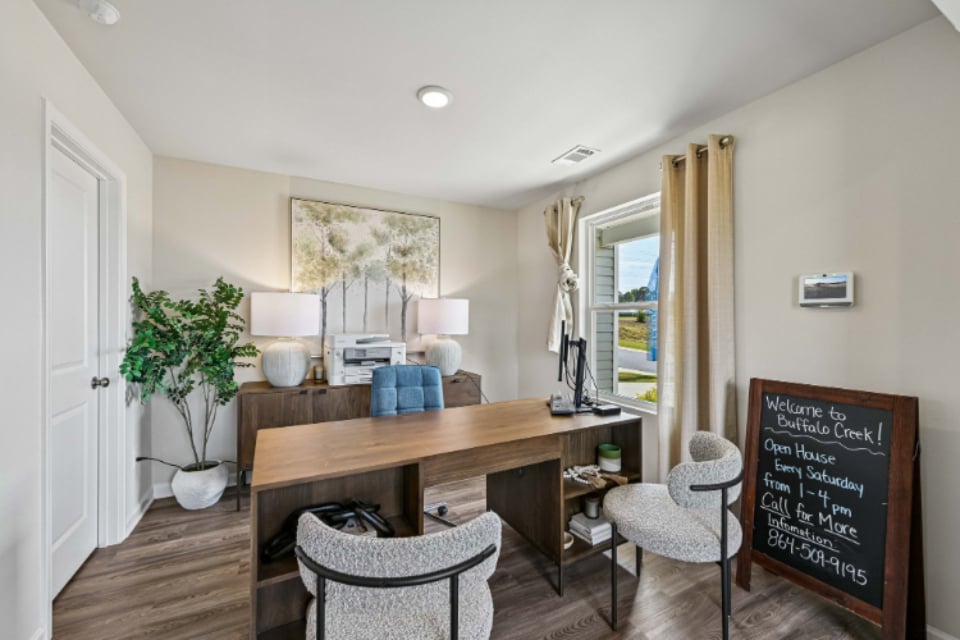 A room with a desk and chairs.