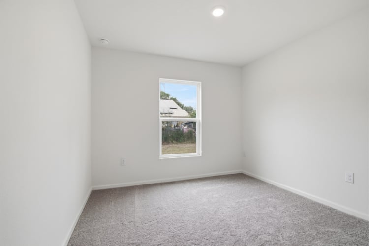 A room with a window and a carpet.