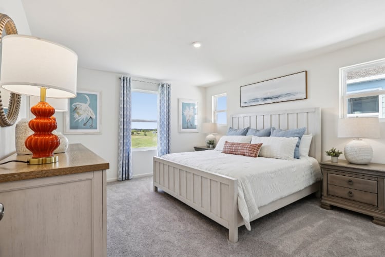 A bedroom with a bed and a lamp.