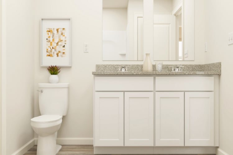 A bathroom with white cabinets.