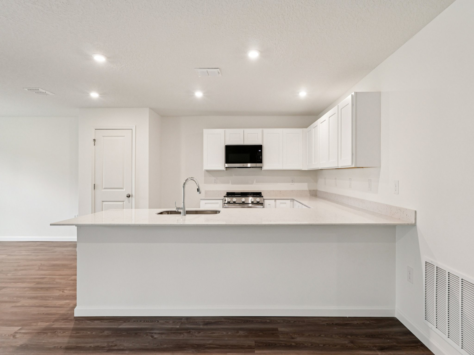 A kitchen with white cabinets.