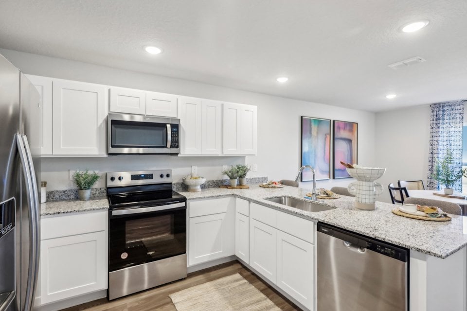 A kitchen with white cabinets.