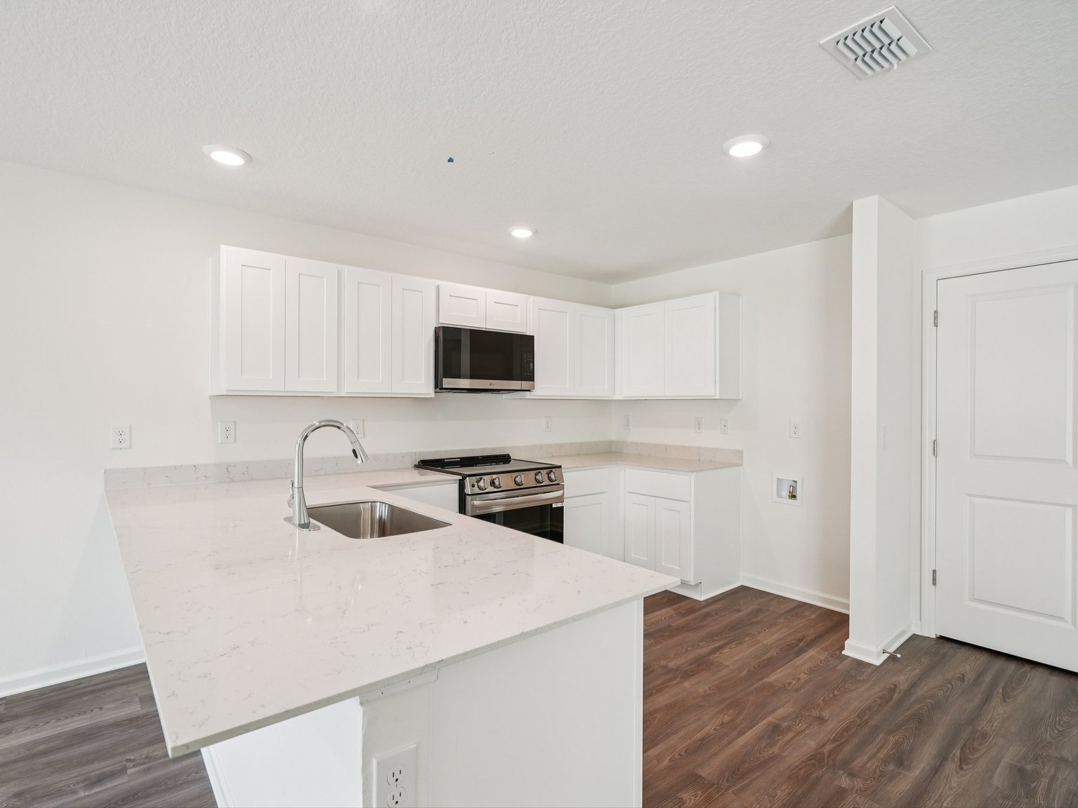 A kitchen with white cabinets.