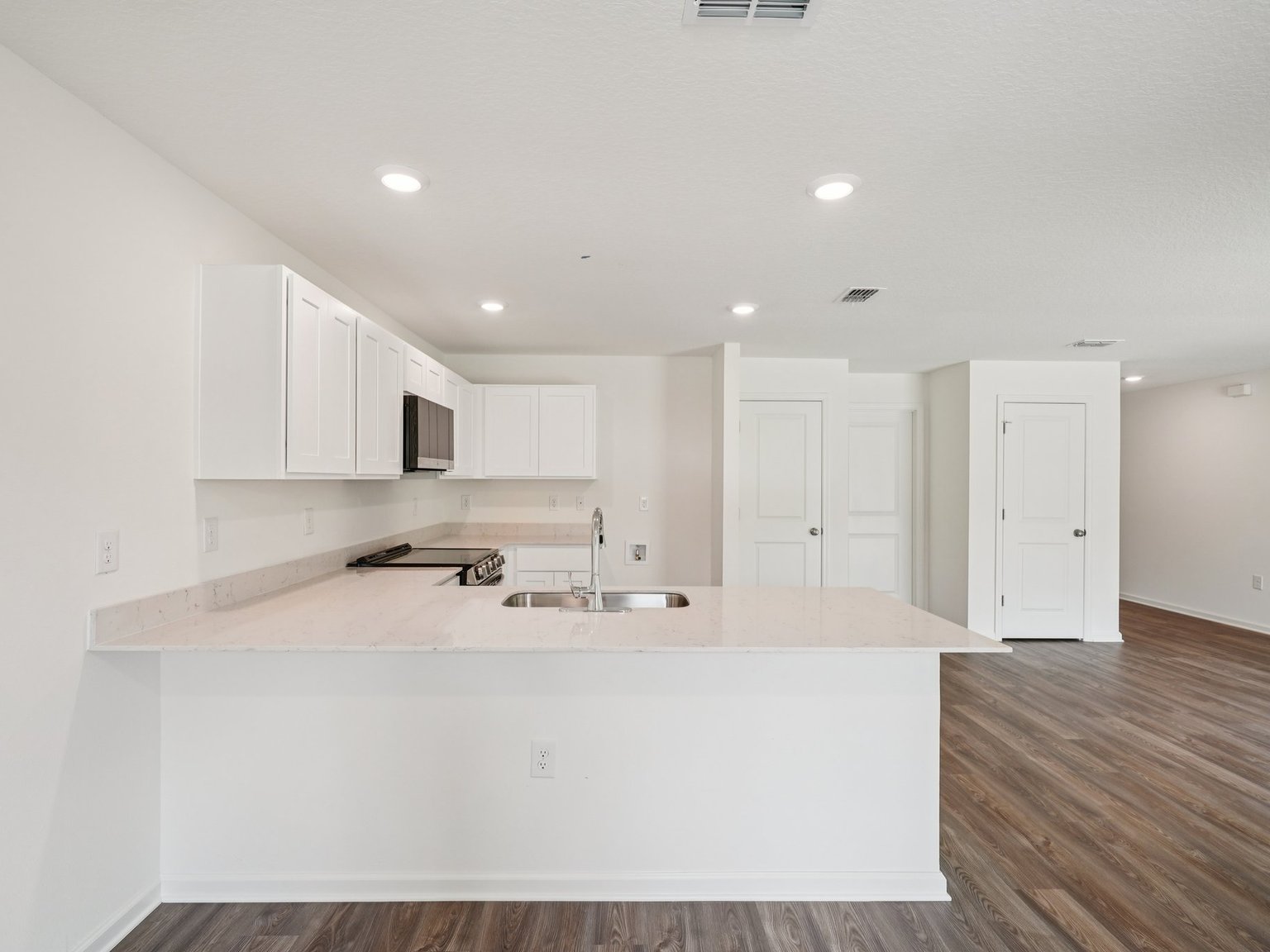 A kitchen with white cabinets.