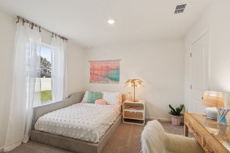 A bedroom with a bed and a table.