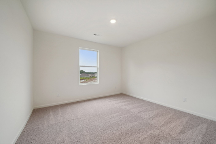 A room with a window and carpet.