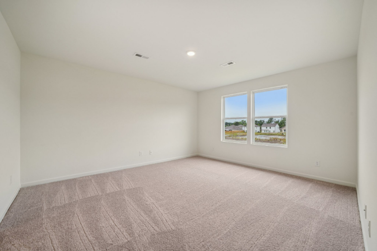A room with a carpet and a window.
