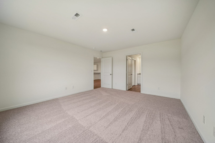 A room with a carpet and a door.