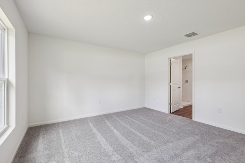 A room with a carpet and a door.