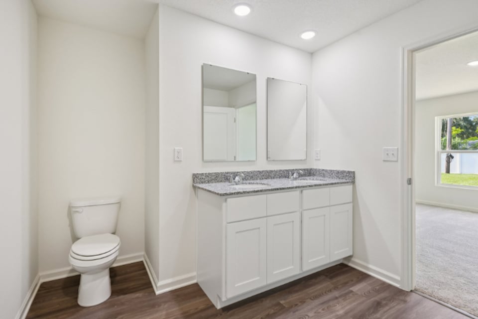 A bathroom with white cabinets.