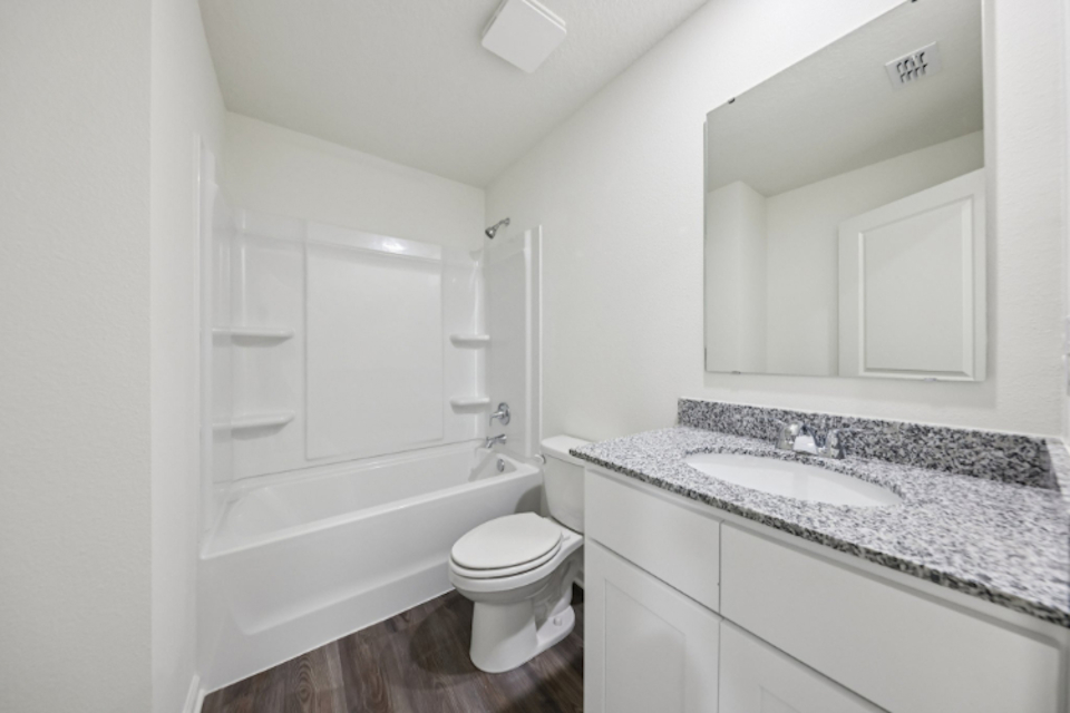A bathroom with a tub sink and toilet.
