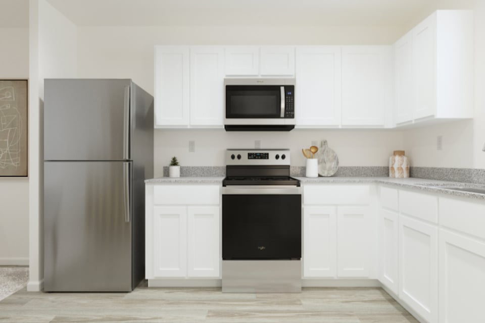 A kitchen with white cabinets.