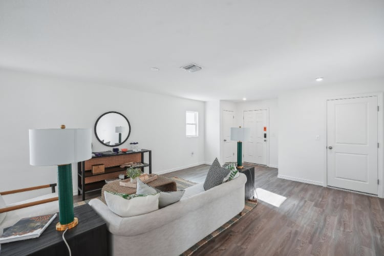 A living room with a couch and a mirror.