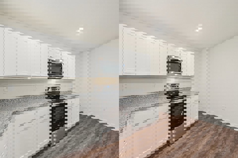 A kitchen with white cabinets.