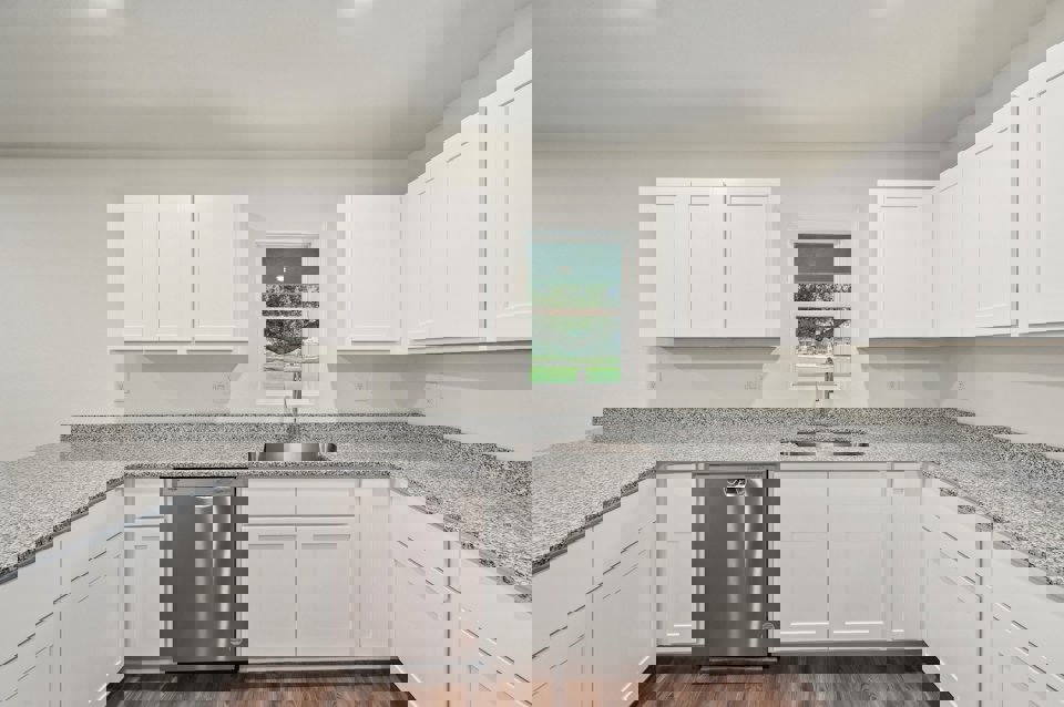 A kitchen with white cabinets.