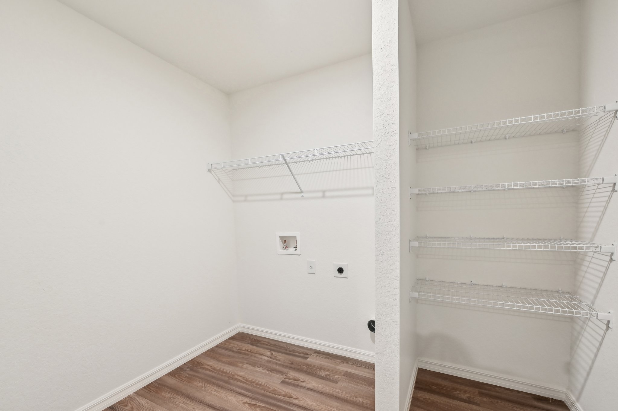 A white room with a wood floor and white walls.