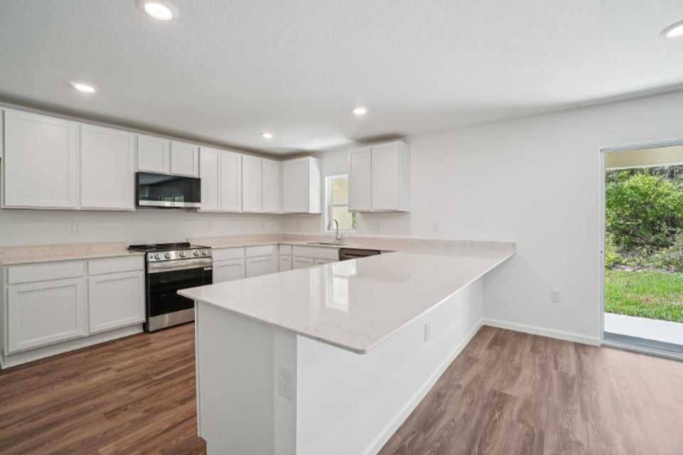 A kitchen with white cabinets.
