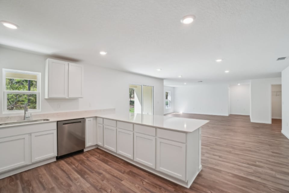 A kitchen with white cabinets.