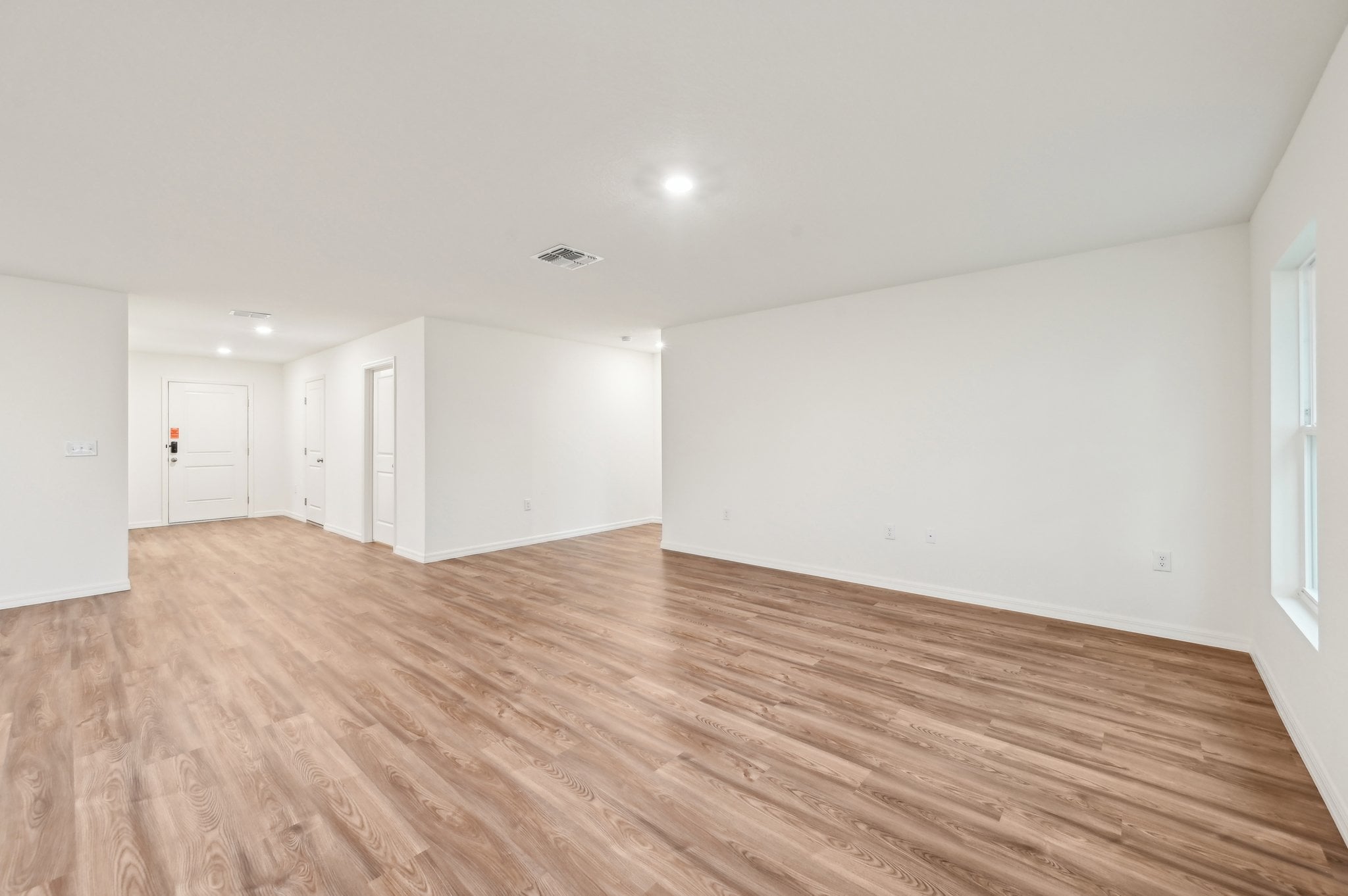 A room with white walls and wood floors.