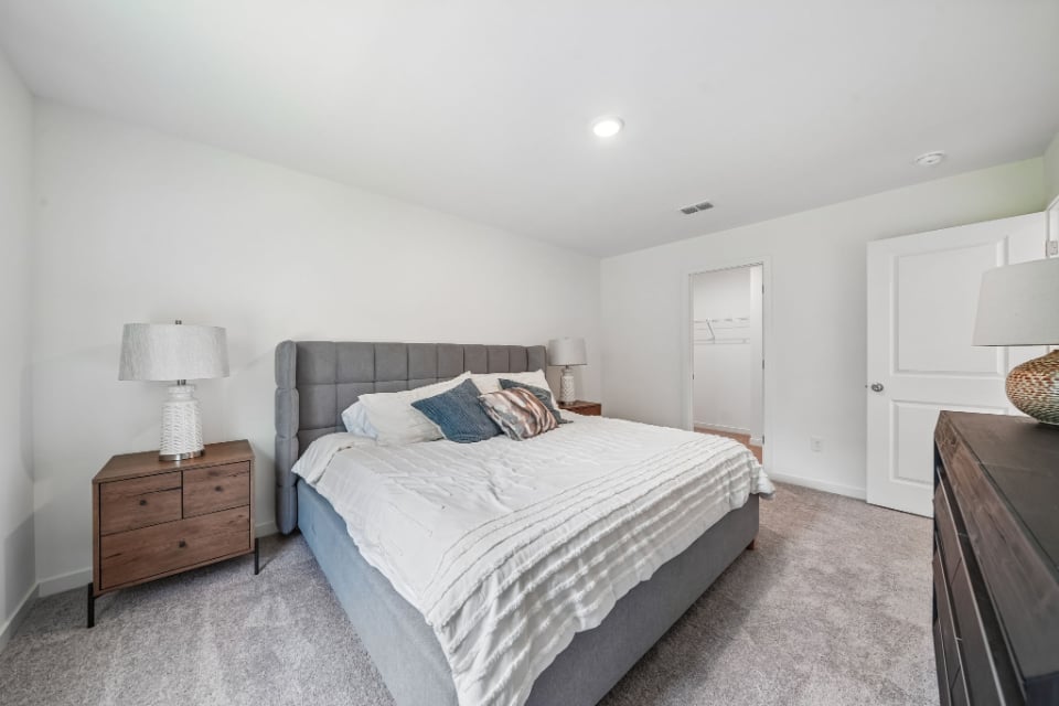 A bedroom with a bed and lamps.