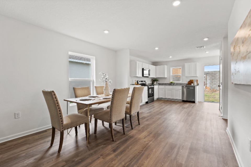 A dining room with a wood floor.