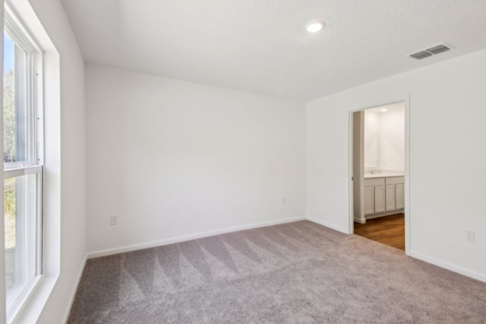 A room with a carpet and a window.