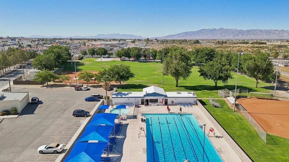 A swimming pool with a building in the background.