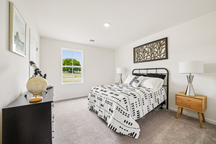 A bedroom with a bed and lamps.