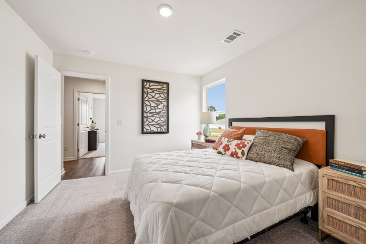 A bedroom with a bed and a dresser.