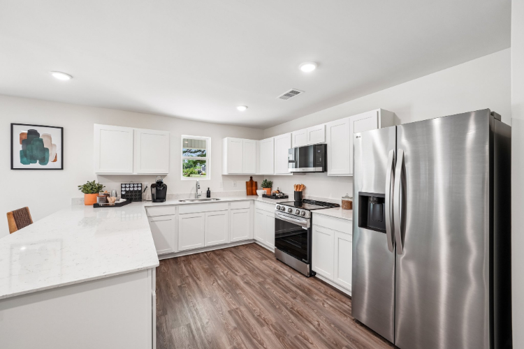 A kitchen with white cabinets.