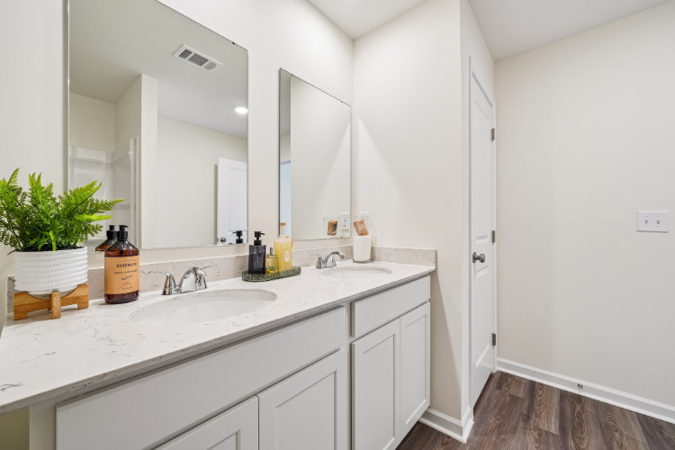 A bathroom with white cabinets.