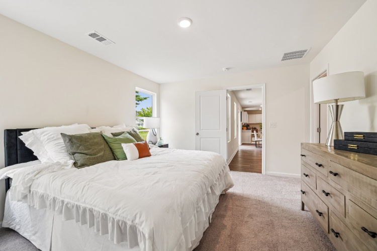A bedroom with a bed and a dresser.