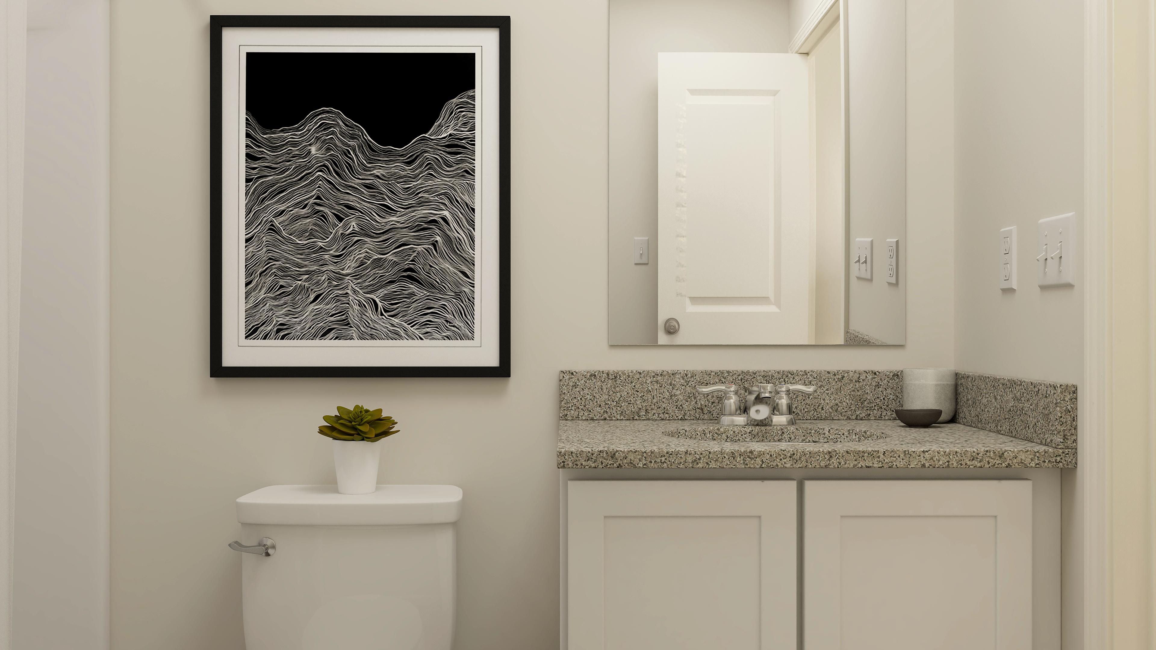 A bathroom with a picture on the wall.