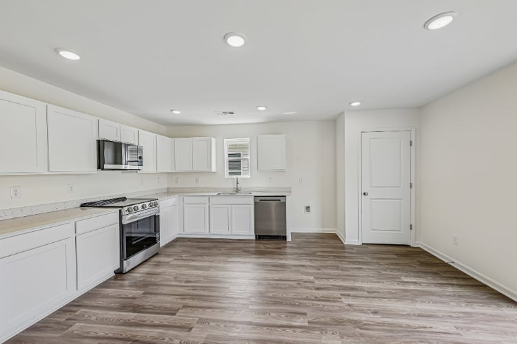 A kitchen with white cabinets.